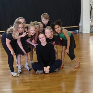 Lapsai tanssisalilla ohjaajan ympärillä