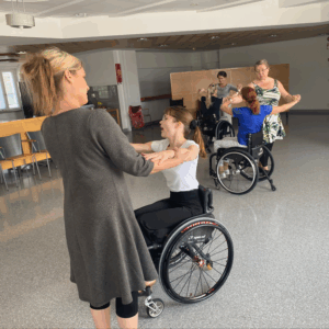 Tanssipareja joissa toinen osapuoli istuu pyörätuolissa.