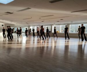 Auringonpaisteessa yksin tanssivia ihmisiä.