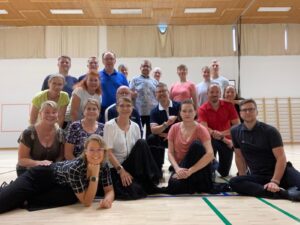 Naisia ja miehiä ryhmäkuvassa.