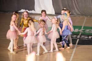 Pieniä tyttöjä tanssimassa piirissä.