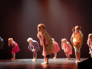 Pieniä tyttöjä tanssimassa mekot päällä.