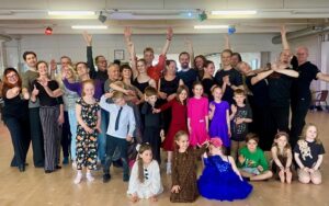 Ryhmäkuva joss lapsia ja aikuisia tanssisalilla,